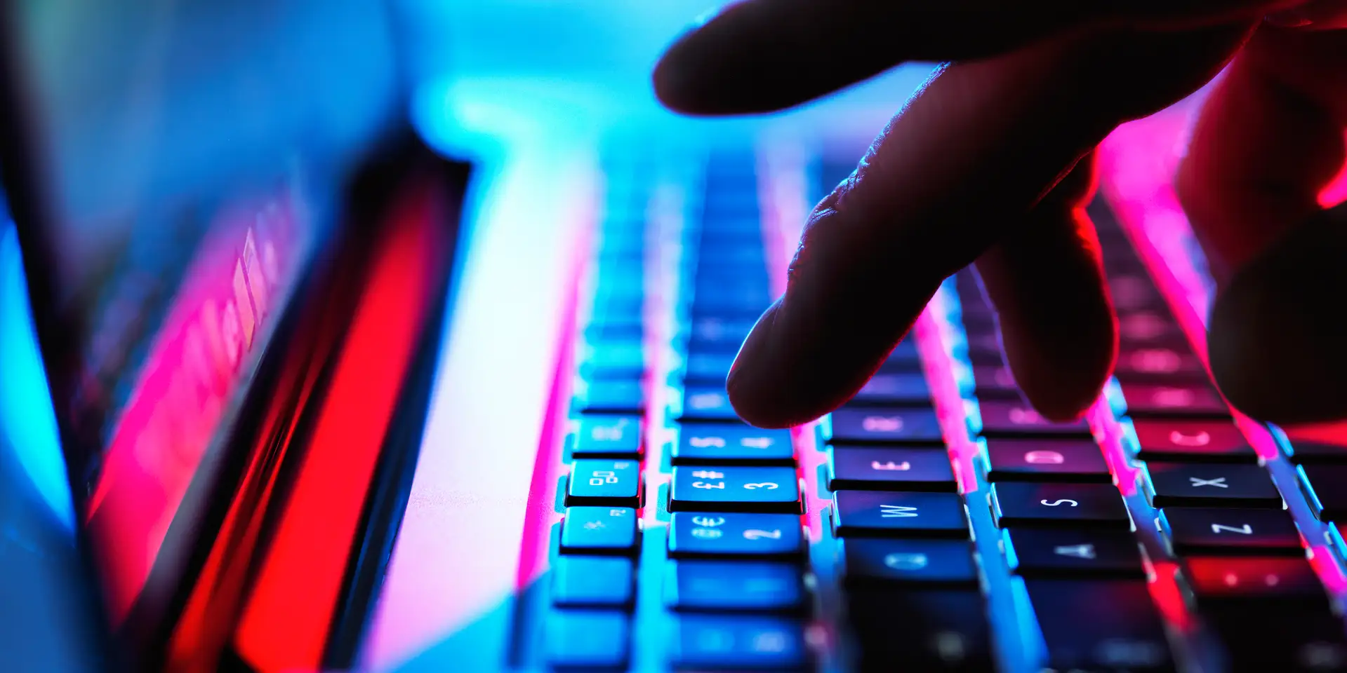 Close-up of person typing on laptop keyboard.